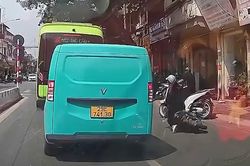 Vừa đi xe máy vừa xem điện thoại, cô gái ngã nhào giữa đường
