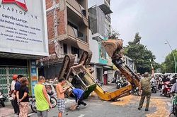 Xe múc 5 tấn lật ngửa ở TP.HCM