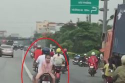Bố chở con ngồi ngược trên xe máy chạy bon bon trên đường
