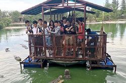 Du khách đứng trên bè tự chế vui đùa giữa bầy cá sấu khiến người xem rùng mình
