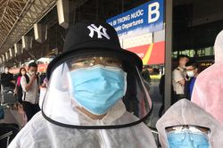 Hành khách mặc đồ bảo hộ kín mít ở sân bay Tân Sơn Nhất