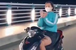 Thả 2 tay để 'múa quạt' khi đi xe máy, cô gái bị phạt 7,4 triệu đồng