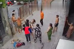 Clip: 2 nhà hàng xóm cầm gậy lao vào hỗn chiến gây náo loạn mặc người phụ nữ nằm gục giữa đường