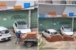 Hai ô tô đỗ trước cửa nhà, người đàn ông xếp hai hàng gạch chặn gây tranh cãi