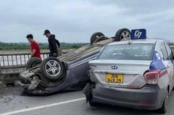 Va chạm với xe taxi, xe Honda Civic lật ngửa trên cầu Vĩnh Tuy