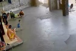 Người lớn bất lực nhìn em bé chạy vào sân bê tông vừa đổ