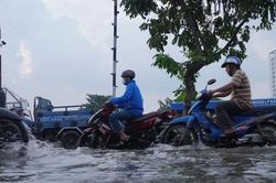 Người dân TPHCM bì bõm về nhà khi triều cường dâng cao
