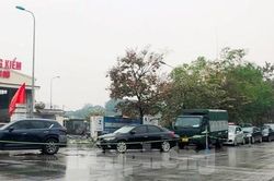 Người dân xếp hàng dưới mưa chờ đăng kiểm ô tô tại Hà Nội