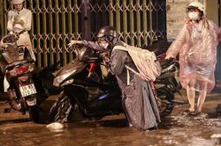 Người dân dắt bộ xe máy về nhà trong cơn mưa lớn tại TPHCM