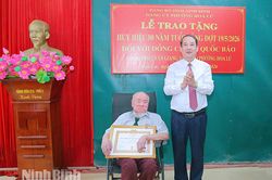 Đồng chí Phó Bí thư Tỉnh ủy, Trưởng Đoàn đại biểu Quốc hội tỉnh Mai Văn Tuất trao Huy hiệu 80 năm tuổi Đảng cho đảng viên phường Hoa Lư