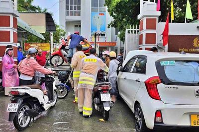 Cảnh sát giao thông Thành phố Hồ Chí Minh hỗ trợ người dân di chuyển qua đoạn đường ngập sâu
