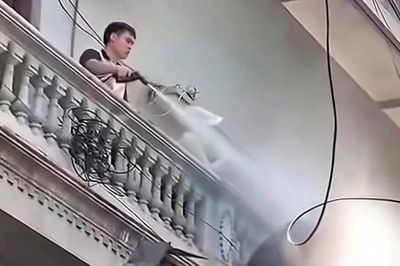 Người đàn ông liên tục xịt nước vào thợ đang tháo dỡ công trình