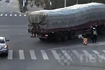 Cảnh sát lao tới kéo người phụ nữ khỏi gầm xe tải trong gang tấc