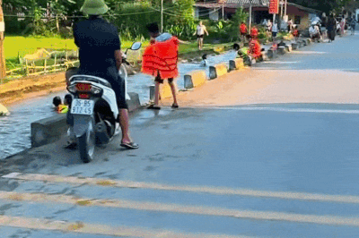 Hàng chục người tắm mát dưới con mương nằm sát đường lớn