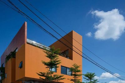 Ngôi nhà màu cam nổi bật trên nền cây xanh