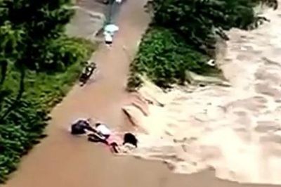 Người đàn ông dũng cảm lao vào nước lũ, cứu tài xế xe máy trong gang tấc
