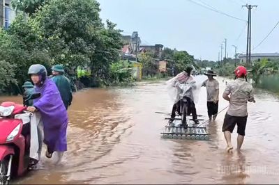 Lực lượng chức năng hỗ trợ người dân qua điểm ngập trên Quốc lộ 279