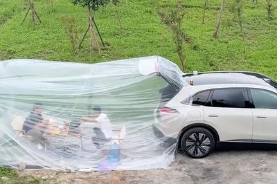 Hai người đàn ông dựng 'phòng điều hòa' sau ô tô để nấu ăn dưới trời nắng nóng