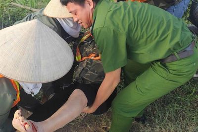 Người phụ nữ nằm gục bên đường sau tai nạn, được cán bộ công an hỗ trợ đưa đi cấp cứu