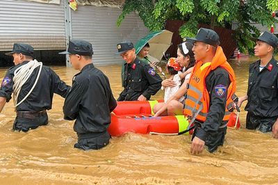 Cảnh sát dầm mình trong nước sâu, đưa người dân khỏi vùng ngập ở Lào Cai