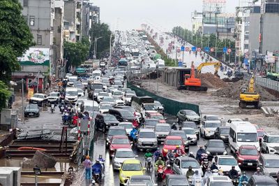 Người Hà Nội đội mưa lớn đi làm, 'chôn chân' trên những tuyến đường ùn tắc
