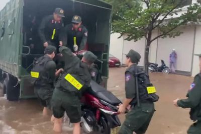 Cảnh sát cơ động hỗ trợ người dân di chuyển qua vùng ngập nước