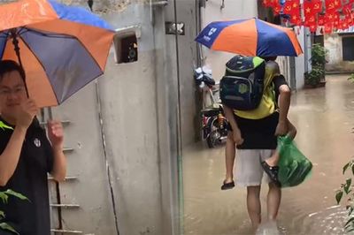 Nhiều tuyến phố Hà Nội ngập sâu, bố lội nước 3 lượt cõng con đến lớp