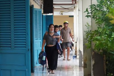 Phụ huynh phải cõng con vào lớp do sân trường ngập sâu