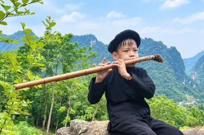 Cậu bé người dân tộc Nùng say tiếng sáo Mông