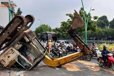 Xe múc đang thi công bất ngờ lật ngửa ra đường