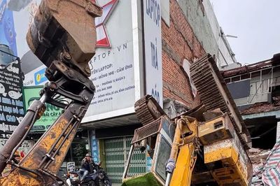 Đang tháo dỡ nhà, xe múc bất ngờ lật ngửa trên đường