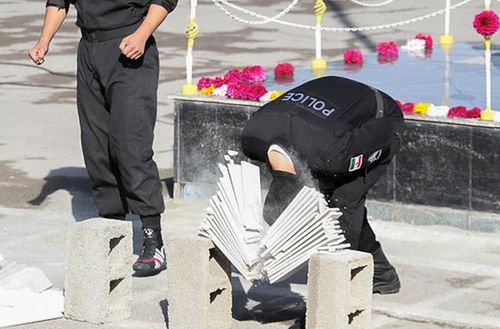  Cảnh sát đặc nhiệm Iran biểu diễn “thiết đầu công” dùng đầu đập vỡ chồng gạch. 