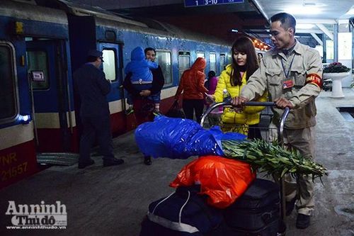 Anh Đào Mỹ Phúc, Tổ trật tự Ga Hà Nội đang giúp đỡ hành khách vận chuyển hành lý. Vợ anh cũng làm việc tại Ga Hà Nội. Đêm Giao thừa năm nay, cả hai vợ chồng anh đều trực ở Ga. "Tôi chỉ lo có hành khách nào nhỡ chuyến tàu cuối khì khổ", anh Phúc tâm sự.