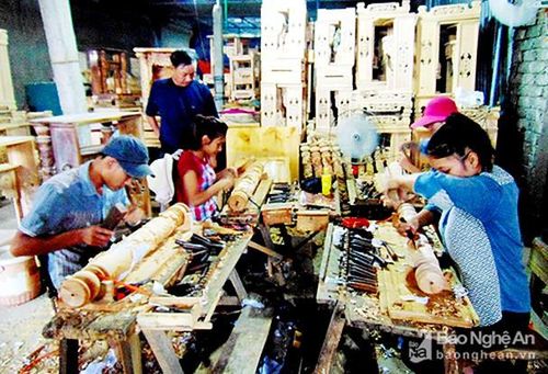 Mô hình sản xuất mộc mỹ nghệ của CCB Hoàng Văn Nguyện (áo đen), xã Quỳnh Thọ cho thu nhập hàng trăm triệu đồng mỗi năm. Ảnh: Thanh Toàn