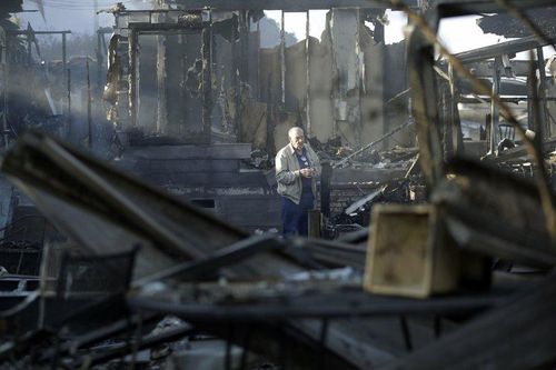 Một người dân trước đống hoang tàn hỏa hoạn gây ra tại Bonsall, California. Hôm 3/12, các quan chức đã đưa các đội cứu hỏa từ phía bắc của bang lên để tiếp viện cùng nhiều máy ủi và máy bay. Hôm 4/12, họ cử thêm trực thăng từ lực lượng Vệ binh Quốc gia và "mọi máy bay cuối cùng mà chúng ta có thể tìm thấy ở trong nước", Thom Porter từ Cục Lâm nghiệp và Chữa cháy California cho biết. 