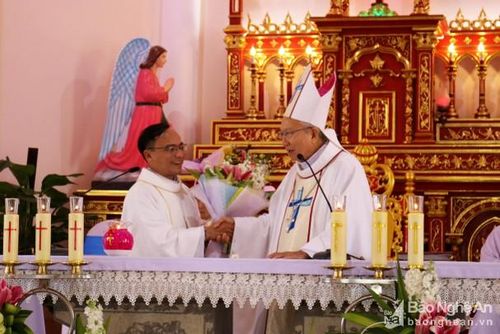 Giám mục Phaolô Nguyễn Thái Hợp tặng hoa chúc mừng linh mục quản xứ Giuse Nguyễn Duy Phương. Ảnh: Huy Thư