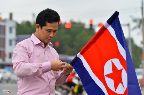 Một cán bộ huyện Hữu Lũng (Lạng Sơn) đang chuẩn bị treo cờ Triều Tiên lên cột điện. Anh cho biết mình mới nhận nhiệm vụ treo 230 lá cờ và sẽ treo xong trước khi ông Kim Jong Un lên đường về nước. 