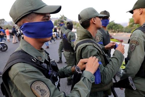 Những người lính ủng hộ Guaido cũng đeo băng xanh lam giống ông. (Nguồn: Guardian)