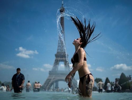  Người phụ nữ làm mát cơ thể tại đài phun nước Trocadéro ở Paris, Pháp. Các nhà khí tượng học cho rằng nhiệt độ tại Pháp tăng cao là do không khí nóng từ phía bắc châu Phi 