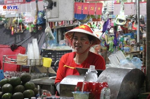 Các cô, các chị tay mua, tay bán nhưng vẫn nở nụ cười rạng rỡ rôm rả vui hơn tết bàn nhau về trận đấu sắp tới của đội tuyển Việt Nam.