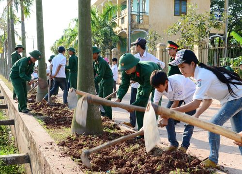 Các em học sinh cùng chiến sĩ Lữ đoàn 673 (Quân đoàn 2) làm đẹp cảnh quan đơn vị. Ảnh: MINH HUỆ.