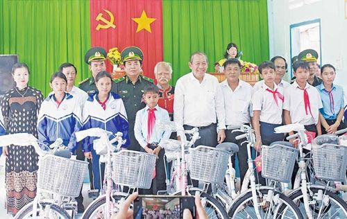 Phó Thủ tướng Thường trực Chính phủ Trương Hòa Bình (thứ 7 từ phải sang) tặng xe đạp cho học sinh khó khăn ở các xã Ia Dom, Ia Nan, Ia Pnôn (huyện Đức Cơ). Ảnh: M.T