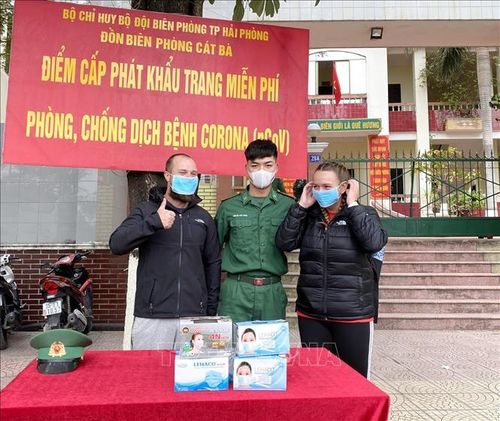 Chiến sĩ Đồn Biên phòng Cát Bà phát khẩu trang miễn phí cho khác nước ngoài du lịch tại đảo Cát Bà. Ảnh: An Đăng/TTXVN