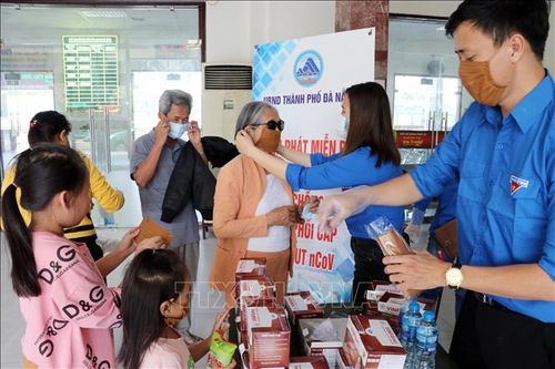 Phát miễn phí khẩu trang cho hành khách đi tàu tại Ga Đà Nẵng. Ảnh: Trần Lê Lâm/TTXVN