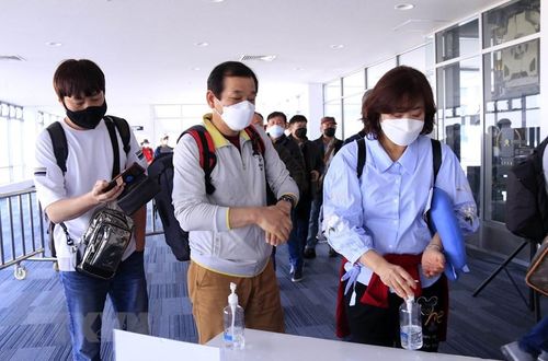 Hành khách đến Lào qua các cửa khẩu quốc tế sẽ được kiểm tra thân nhiệt, sau đó sẽ được yêu cầu sát khuẩn tay trước khi nhập cảnh Lào. (Ảnh: Phạm Kiên/Vietnam+)
