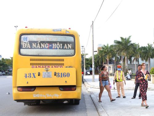  Du khách đi trên xe Buýt Đà Nẵng - Hội An được yêu cầu xuống xe để đo thân nhiệt và khai báo lịch trình. 
