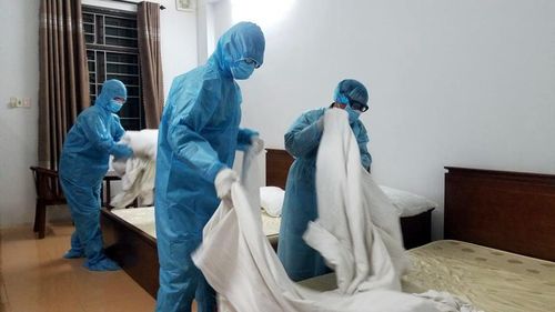 Các nhân viên bên trong dọn dẹp thay mới chăn ga của những người vừa được ra khỏi khu cách ly.