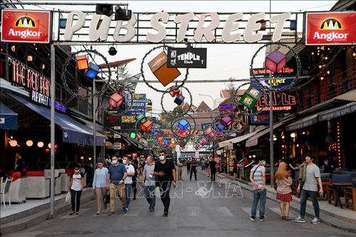 Khách du lịch đeo khẩu trang phòng dịch COVID-19 tại điểm thăm quan ở tỉnh Siem Reap, Campuchia. Ảnh: AFP/TTXVN
