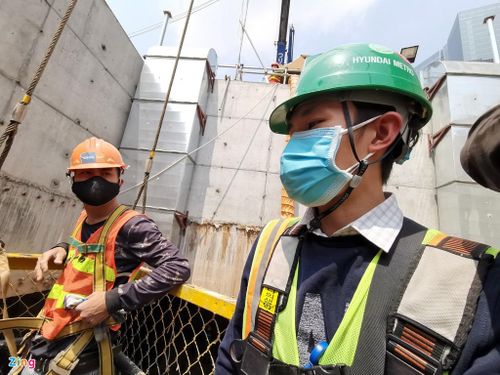 Các công nhân lên xuống ga ngầm thông qua một hệ thống vận thăng có cần cẩu điều khiển. Mọi người trước khi vào công trường đều phải đo thân nhiệt và phải có khẩu trang, đồ dùng bảo hộ.