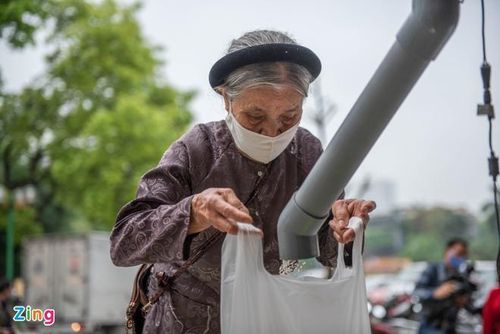  Chứng kiến nhiều gia đình nghèo bị "đứt bữa" do dịch, ông Hùng cùng nhóm bạn đã quyết tâm thiết kế một máy phát tự động và bỏ tiền mua 3 tấn gạo miễn phí cho người nghèo. Khoảng 9h ngày 11/4, khá đông người tới Trung tâm Thể thao - Văn hóa phường Nghĩa Tân, quận Cầu Giấy, Hà Nội, xếp hàng cách nhau 2 mét để nhận gạo miễn phí. Ảnh: Hải Nam. 